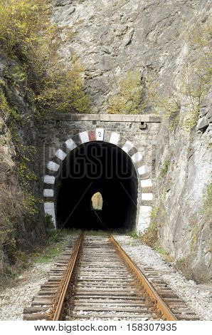 Old railway stone tunnel closeup in autumn day