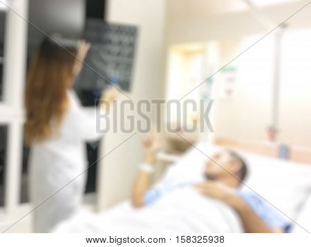 Blurry Doctor consultations with patients. Doctor holding X-ray to the patient.