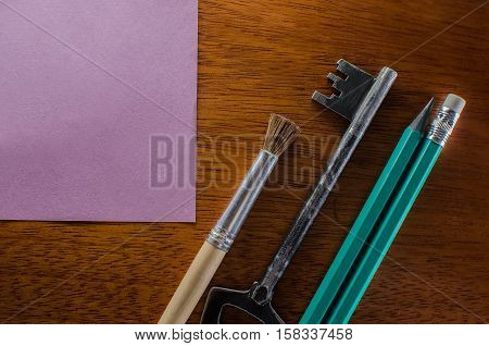 On a wooden table in the office, lie pencils, items key sticker for school of business education