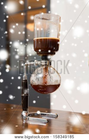 equipment and technology concept - close up of siphon vacuum coffee maker at shop over snow