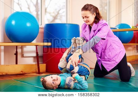 Cute Kid With Disability Has Musculoskeletal Therapy By Doing Exercises In Body Fixing Belts