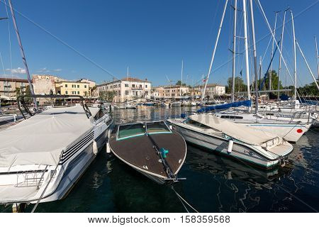 BARDOLINO, ITALY - MAY 4, 2016: Sailboats and fishing boats at Porto di Bardolino harbor on The Garda Lake . Italy