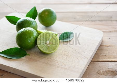 Lemons with green leaf on wooden background