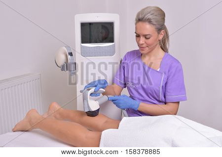 Young beautiful woman gets professional body shape treatment in a beauty clinic