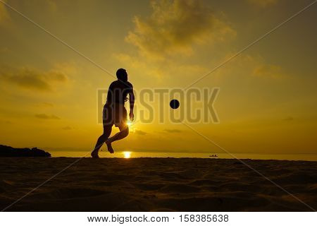 Silhouettes of footballers on the sunset sky