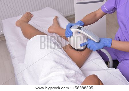 Young beautiful woman gets professional body shape treatment in a beauty clinic
