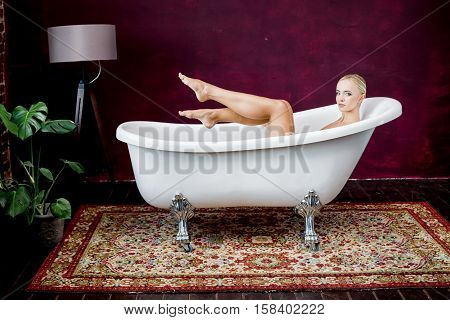 portrait of beautiful sexy young woman in bath. Nude slim body of the beautiful woman with blond hair. beautiful sexy blond woman with big breast. Big boobs.
