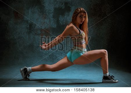 Attractive girl dancing twerk iat the blue studio background