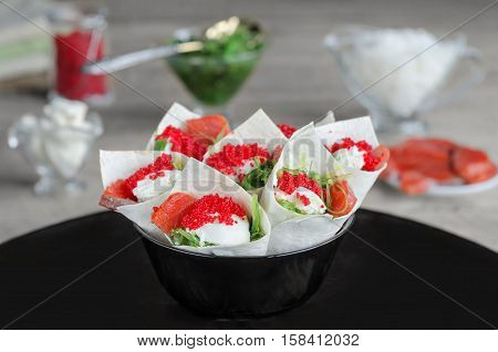 Sandwiches with seafood and ingredients in envelopes of tortillas. Selective focus.