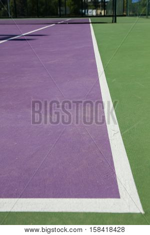 Lines of the corners of a cement tennis court. Track colors are purple and green.