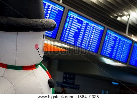 Snowman on the background of the schedule of flights to Moscow Vnukovo airport