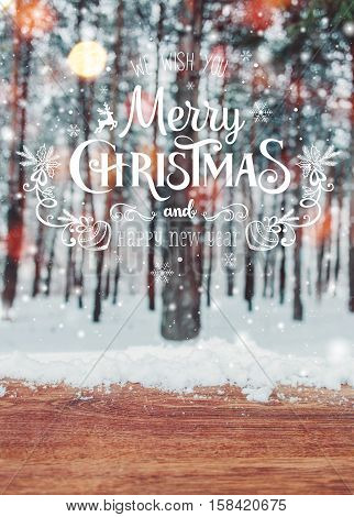Christmas background with fir trees and blurred background of winter with text Merry Christmas and Happy New Year and wooden table with snow place. Frosty winter landscape in snowy forest