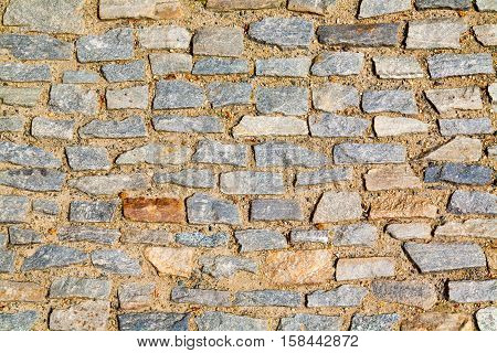 Stone pavement texture. Granite cobblestoned pavement background. Abstract background of old cobblestone pavement close-up.