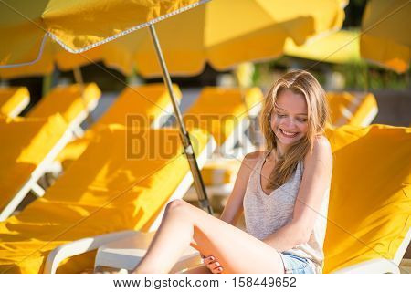 Girl Relaxing On A Beach Chair Near The Sea