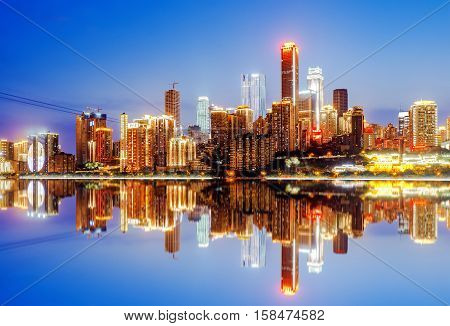 cityscape and skyline of downtown near water of chongqing at night