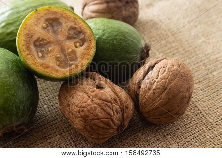 Feijoa fruit and walnuts on linen background