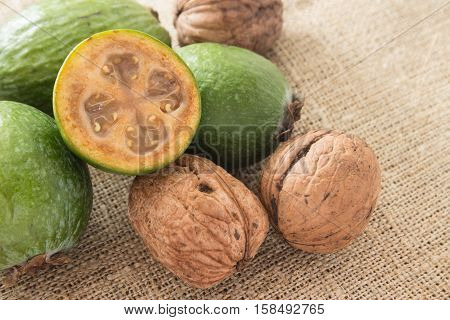 Feijoa fruit and walnuts on linen background
