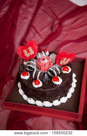Black forest cake whole pastry decorated with whipped cream, red cherry, double happiness, and shuang xi love heart