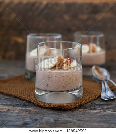 View of chocolate pana cota with banana and goji berry on a wooden table