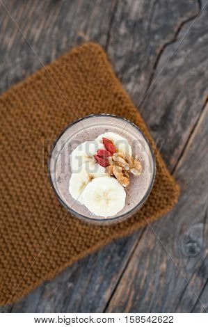 View of chocolate pana cota with banana and goji berry on a wooden table