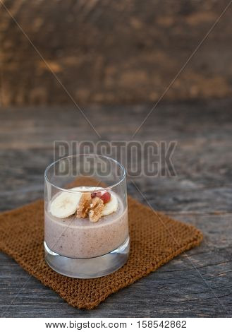 View of chocolate pana cota with banana and goji berry on a wooden table