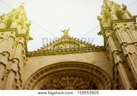 Looking up at the towers of the Cathedral La Seu Palma de Mallorca Mallorca Balearic Islands Spain on a sunny day. Tilt-shift lens used to accent the cathedral and to emphasize the Christ statue