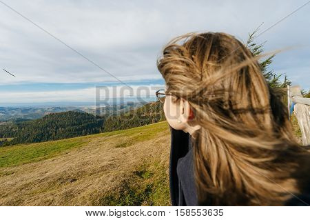 Young beautiful woman wearing glasses contemplating mountains and model plane the hills looking toward new experiences love job dream house children and bright future