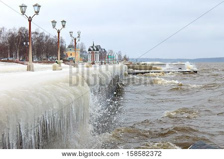 Winter storm on the lake and ice-covered city embankment. Onegalake, Petrozavodsk, Russia