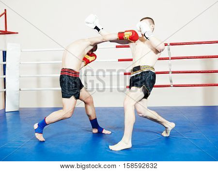 Muay thai sportsman fighting at boxing ring