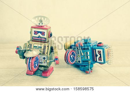 Old robot toy on wood table, vintage color style, vintage tone background.