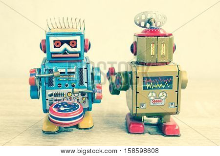 Old robot toy on wood table, vintage color style, vintage tone background.