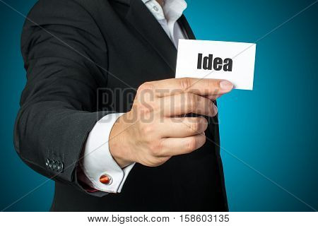 Businessman with idea card on chest in black suit