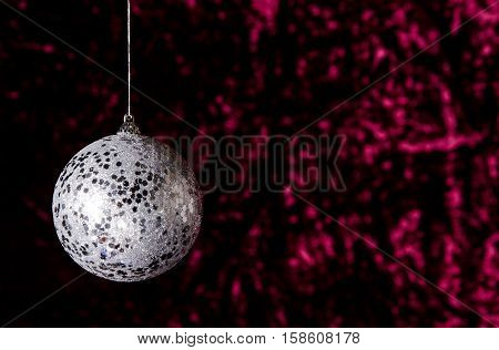 Hanging New Year Ball On A Dark Red Background