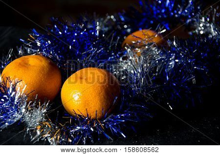 Christmas tangerine or mandarin in tinsel for new year