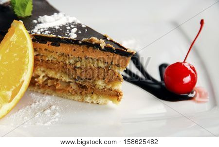 Chocolate cake with red cherry and cream.