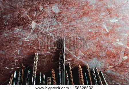 On the old table are screws of different sizes texture background