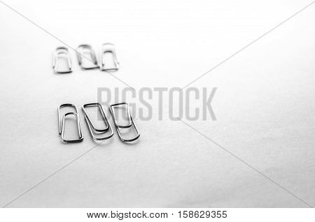 Paperclips scattered on a white background stationery metal office in a different order