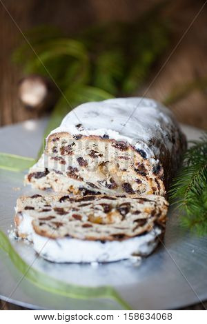 Christmas stollen. Traditional German, European festive dessert. Ingredients cranberries, pine nuts for Christmas Stollen. Stollen cake cut into pieces. Christmas food card.
