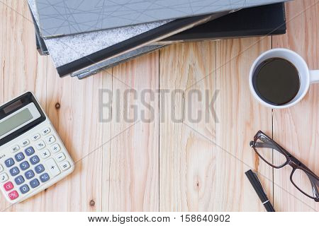 top view : "work hard" stack of document folders laptop coffee cup eyeglasses pen on wood table with copy space