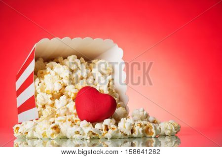 Fresh popcorn spilled out of the box on a red background