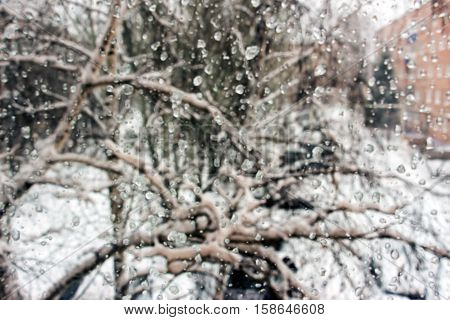 Blurred Frozen Drops on glass. Rain and snow outside the window