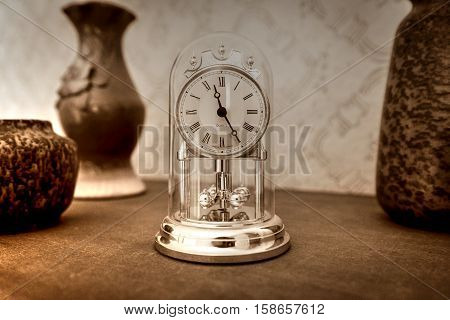 Old style shelf clock with vases monochrome image.