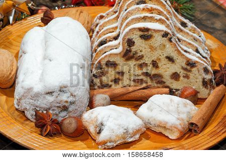 Christmas stollen with Christmas decoration on a wooden plate