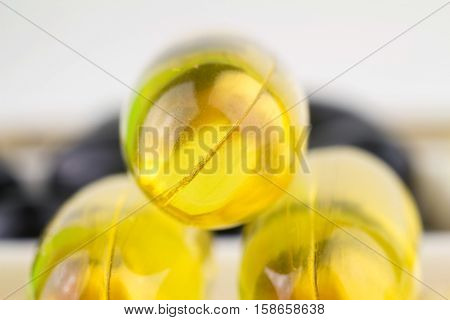 Natural food supplement yellow gel pill fatty acid omega 3 capsules fish oil macro image