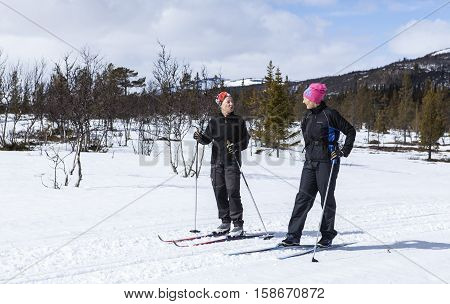 SCANDES, SWEDEN ON APRIL 27. View of two unidentified women cross-country skiing along a trail on April 27, 2013 in the Scandes, Sweden. Track and forest. Editorial use.