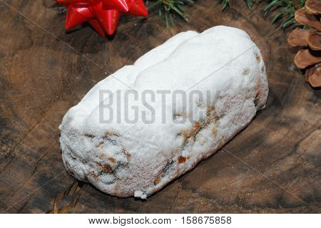 Christmas stollen with Christmas decoration on a wooden plate