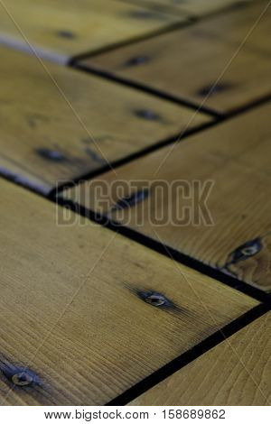 Cedar deck boards with screws and strong linear pattern in warm tones