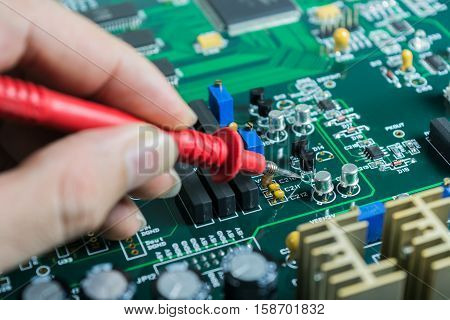 Male hands close up checking voltage on transistor