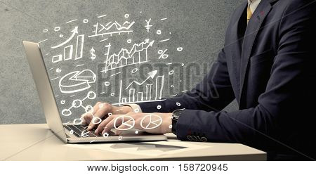 Sales person in suit using a laptop to calculate pie chart and exponential growth statistics on office desk concept