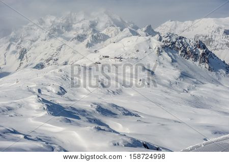 Alpine winter mountain landscape. French Alps covered with snow in sunny day. Val-d'Isere, France